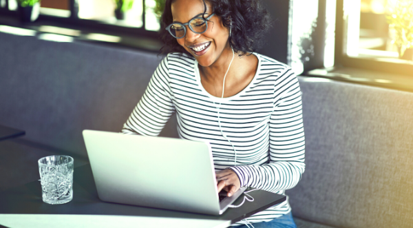 Picture of lady using a laptop and smiling.